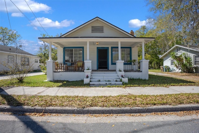 view of front facade featuring a porch and a chimney