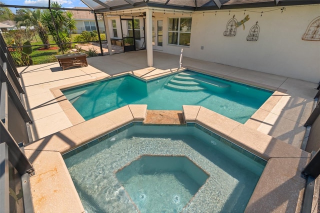 view of swimming pool featuring glass enclosure, a patio area, and a pool with connected hot tub