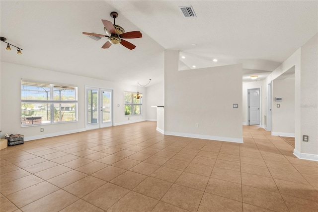 unfurnished living room with light tile patterned floors, visible vents, ceiling fan with notable chandelier, and vaulted ceiling