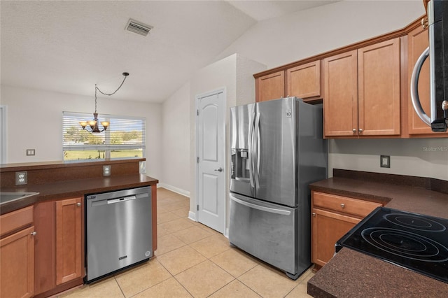 kitchen with stainless steel appliances, dark countertops, and visible vents