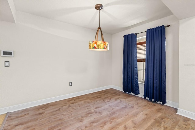 spare room with wood finished floors and baseboards