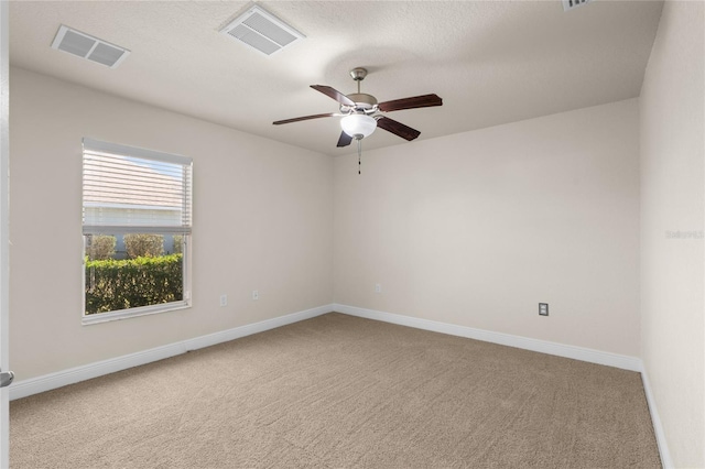 unfurnished room with visible vents, baseboards, carpet, and ceiling fan