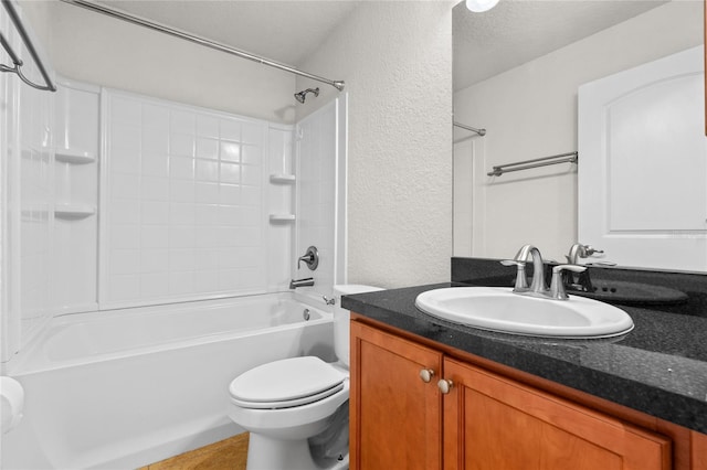 bathroom featuring tub / shower combination, toilet, vanity, and a textured wall