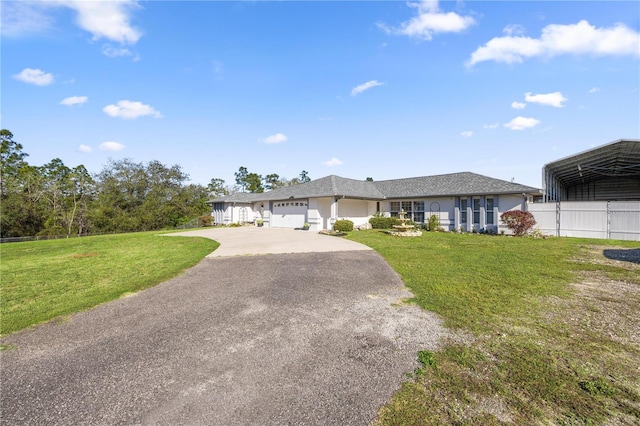 view of front facade with a front lawn, an attached garage, a detached carport, and driveway