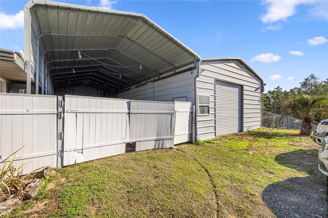 view of outdoor structure featuring a carport and fence