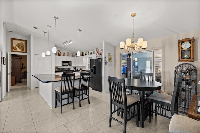 dining space with lofted ceiling, a notable chandelier, light tile patterned flooring, and visible vents