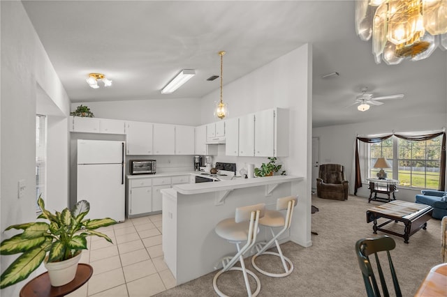 kitchen featuring white appliances, a peninsula, light tile patterned flooring, light countertops, and vaulted ceiling