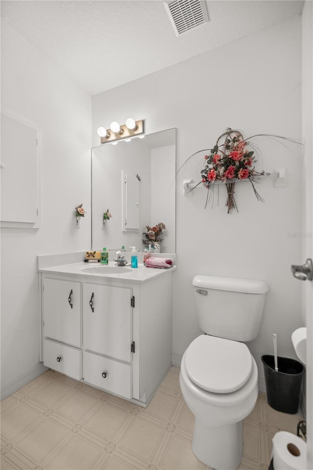 bathroom with tile patterned floors, visible vents, toilet, and vanity