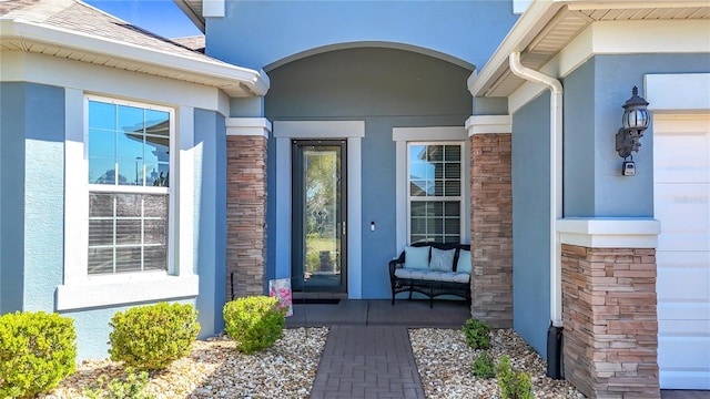 doorway to property featuring stone siding and stucco siding