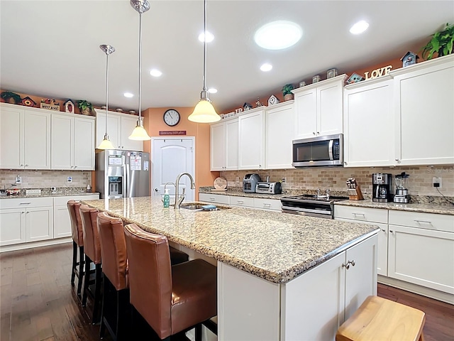 kitchen with a kitchen island with sink, appliances with stainless steel finishes, white cabinetry, and a sink