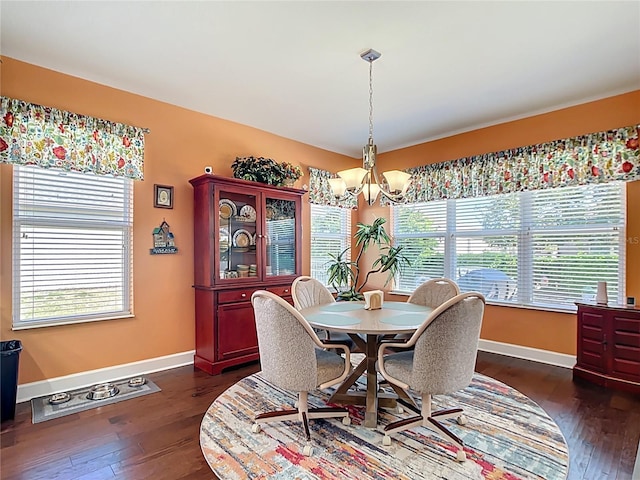 dining space featuring a chandelier, dark wood finished floors, and baseboards