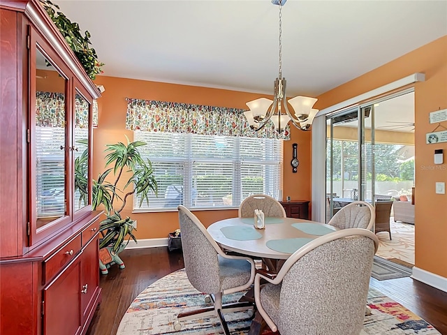 dining area with dark wood-style floors, baseboards, and a chandelier