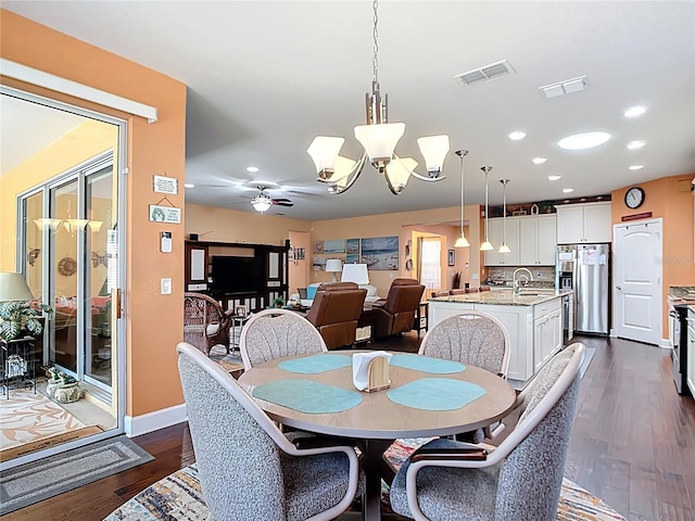 dining space with visible vents, dark wood-style flooring, and ceiling fan with notable chandelier