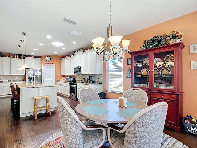 dining area with visible vents, recessed lighting, an inviting chandelier, and dark wood-style flooring