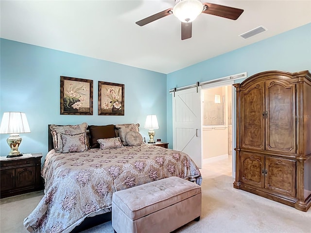 bedroom with visible vents, light colored carpet, a ceiling fan, and a barn door