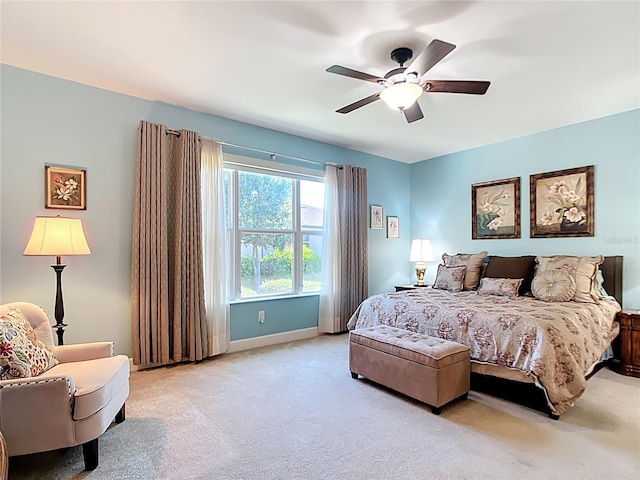 carpeted bedroom with ceiling fan and baseboards