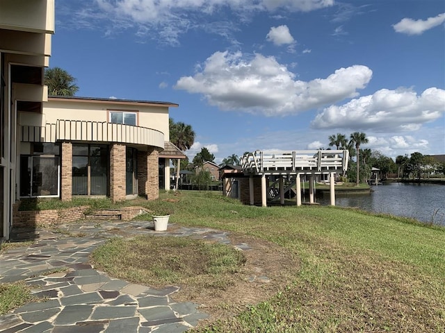 view of yard featuring a balcony and a water view