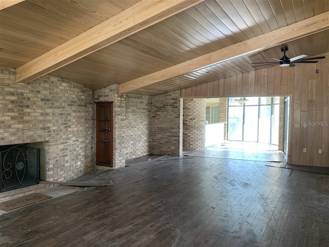 unfurnished living room featuring hardwood / wood-style floors, brick wall, vaulted ceiling with beams, a fireplace, and ceiling fan