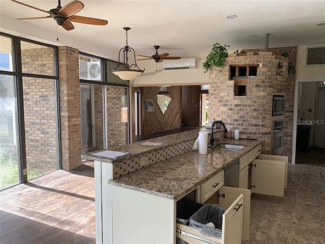 kitchen with a wall mounted air conditioner, a ceiling fan, a sink, white cabinetry, and stainless steel appliances