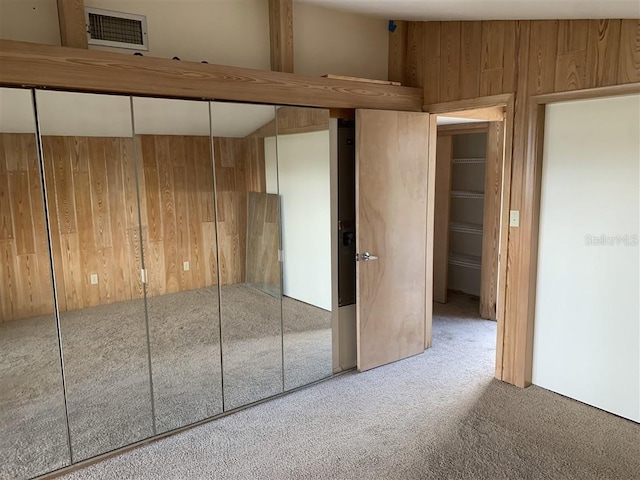 interior space featuring wooden walls, carpet, and visible vents