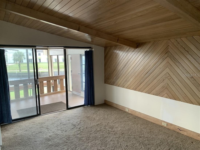 carpeted empty room featuring lofted ceiling with beams, wooden walls, and wood ceiling