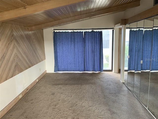 carpeted spare room with lofted ceiling with beams, wooden walls, and wood ceiling