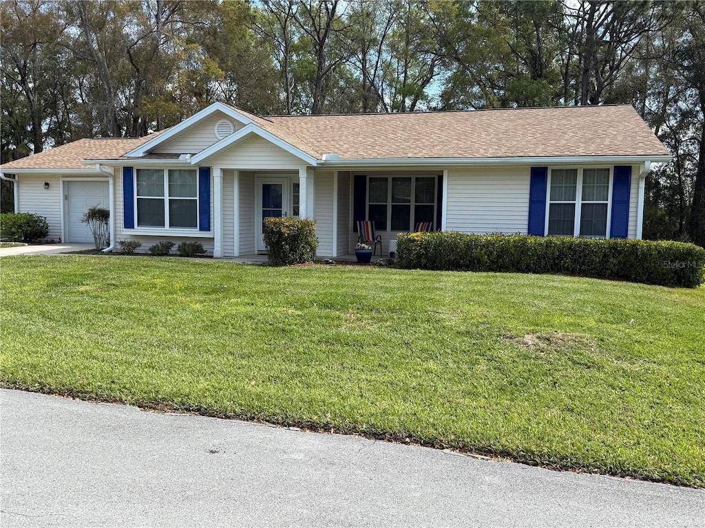 single story home with a front yard, an attached garage, and a shingled roof