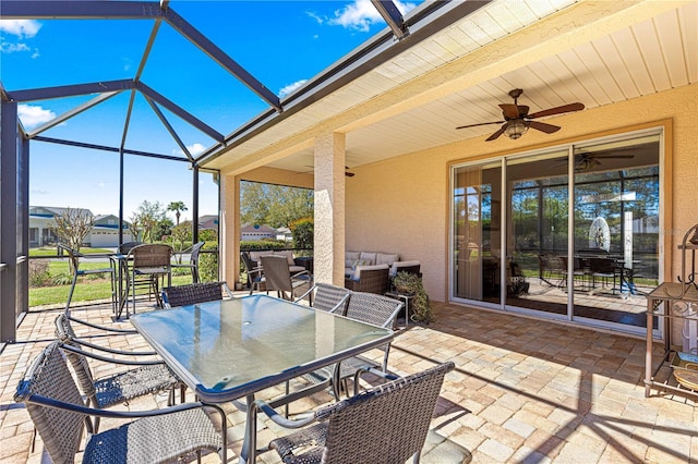 view of patio with a lanai, outdoor dining area, an outdoor hangout area, and ceiling fan