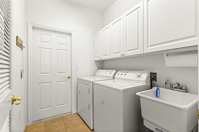 clothes washing area with a sink, cabinet space, independent washer and dryer, and light tile patterned flooring