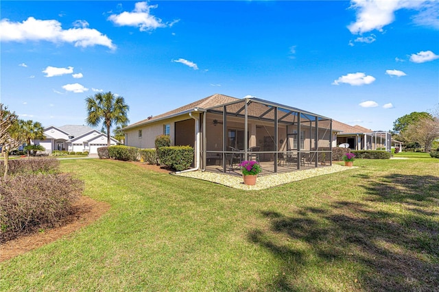 back of house featuring glass enclosure, a patio, a yard, and stucco siding