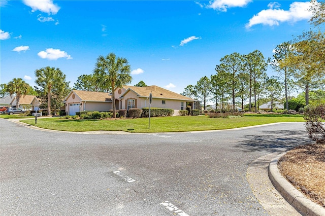 ranch-style home with a front lawn, an attached garage, and stucco siding