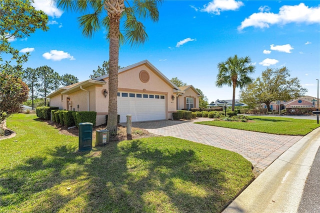 view of front of home with stucco siding, a front lawn, decorative driveway, and a garage