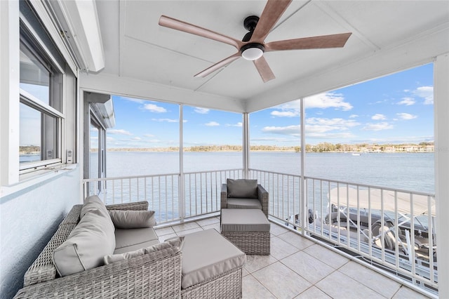 sunroom / solarium featuring a water view and a ceiling fan