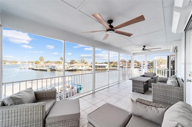 sunroom / solarium with a water view and a ceiling fan