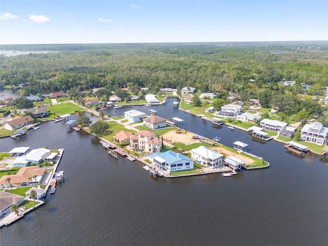 aerial view featuring a wooded view, a residential view, and a water view