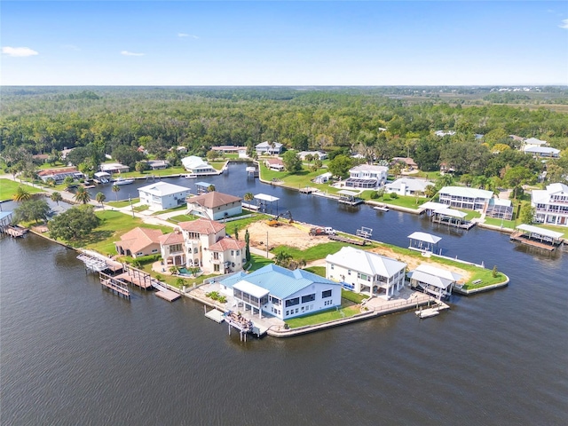 drone / aerial view with a forest view, a residential view, and a water view