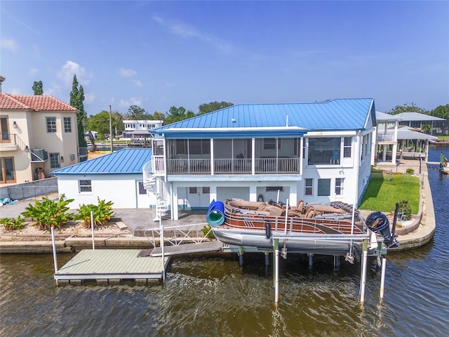 dock area with boat lift, a patio, and a water view