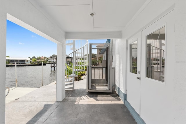 view of exterior entry featuring a water view and stucco siding