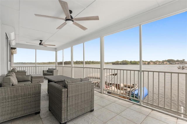 sunroom / solarium featuring a water view and ceiling fan