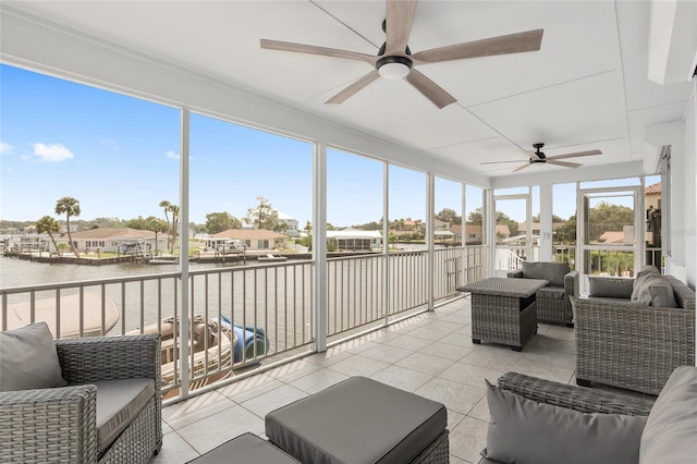 sunroom / solarium featuring a ceiling fan and a water view