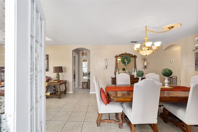 dining room with visible vents, baseboards, light tile patterned flooring, arched walkways, and a notable chandelier