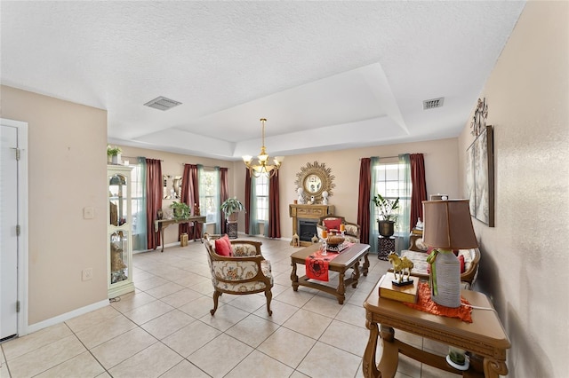 living area with visible vents, a raised ceiling, and a chandelier