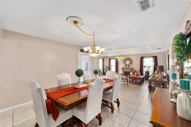 dining room featuring light tile patterned floors, visible vents, a textured ceiling, and an inviting chandelier