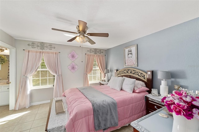 bedroom featuring ensuite bath, light tile patterned flooring, and a ceiling fan