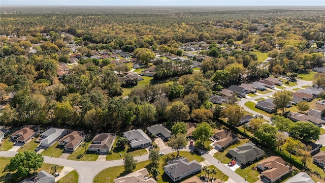 drone / aerial view featuring a residential view and a wooded view