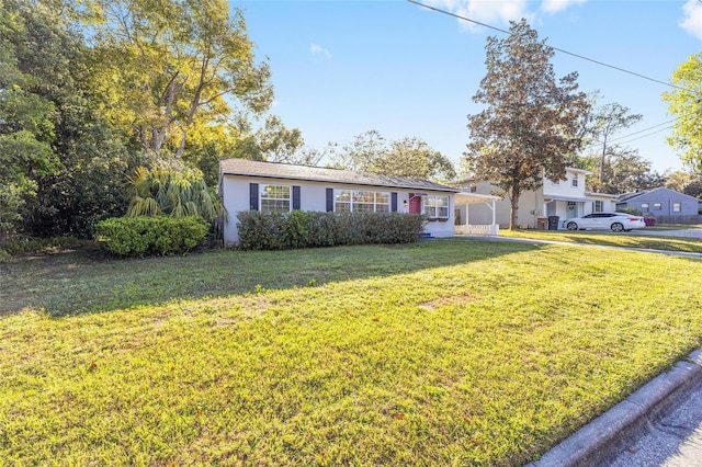 ranch-style home featuring a front lawn and concrete driveway