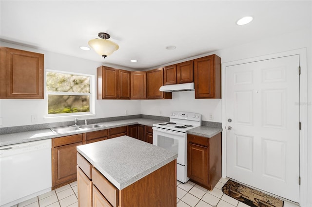 829 NE 15th Ave, Ocala, FL 34470 - kitchen with brown cabinets, a sink, under cabinet range hood, white appliances, and light countertops