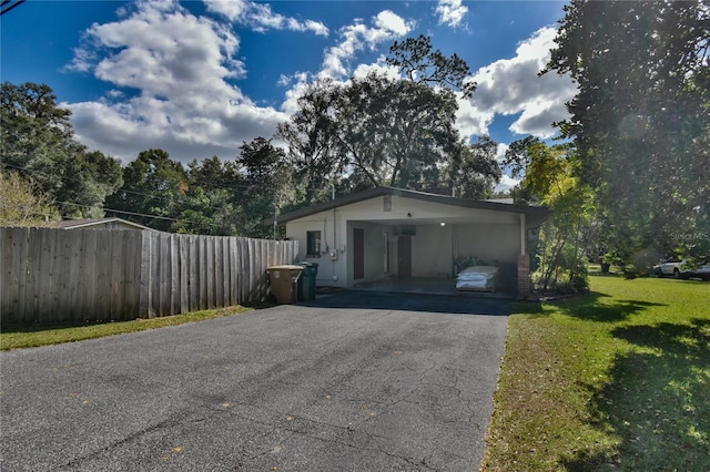 garage featuring aphalt driveway and fence