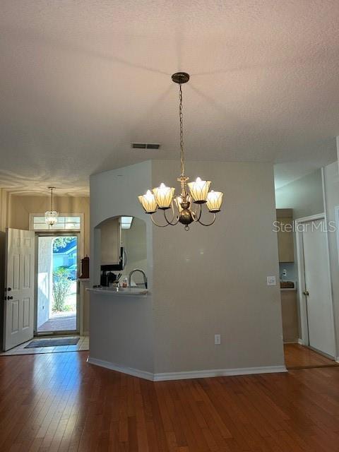 kitchen with visible vents, a notable chandelier, and wood finished floors
