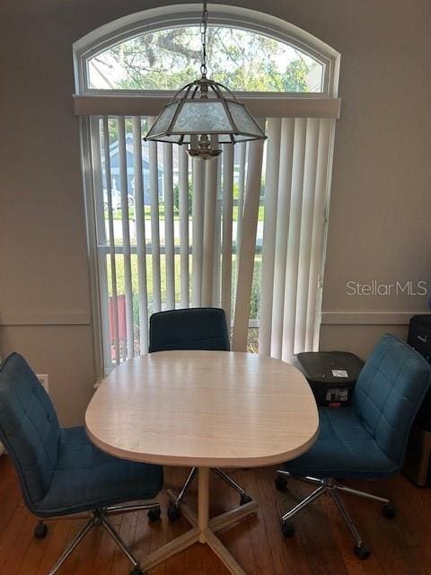 dining area featuring a healthy amount of sunlight, a notable chandelier, and wood finished floors